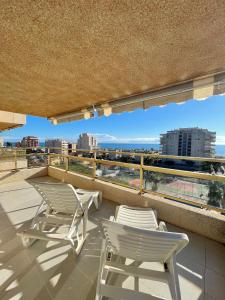 a balcony with chairs and a view of a city at Alpen1 Mediterráneo in Peniscola