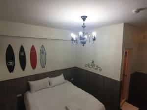 1 dormitorio con cama y tablas de surf en la pared en 戀愛逢甲 en Taichung