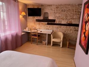 een slaapkamer met een bureau en 2 stoelen en een bed bij Hostellerie Au rendez-vous des amis in Chaumont