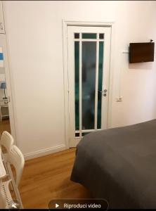 a bedroom with a bed and a door with a window at B&B Rivalta - Posillipo in Naples