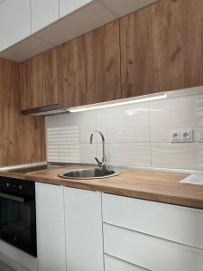 a kitchen with white cabinets and a sink at 7th Sky in Doboj