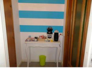a room with a white table and blue and white stripes at B&B Rivalta - Posillipo in Naples