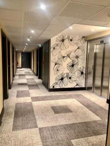a hallway of an office with a flower mural on the wall at COURRIER SUD in Quint-Fonsegrives