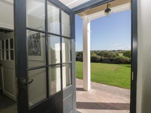 an open door to a patio with a view of a field at Pentwyn Farm in Raglan