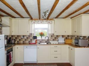 a kitchen with white cabinets and a window at Glan Wye in Rhayader