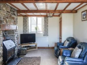 a living room with two leather chairs and a television at Glan Wye in Rhayader