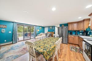 cocina y comedor con mesa y cocina con paredes azules en River Retreat, en Brant Lake