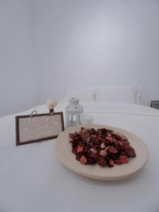 een taart op een bord op een bed met een bord bij The Cozy Place by Nestcove in Melaka
