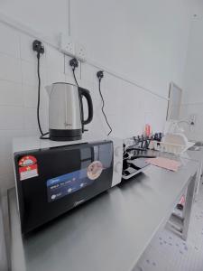 un microondas en la parte superior de un mostrador en la cocina en The Cozy Place by Nestcove en Melaka