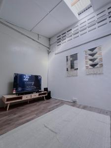 a room with a flat screen tv and a table at The Cozy Place by Nestcove in Melaka