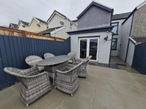 a patio with a table and chairs and a fence at Stylish & comfortable 4 bedroom home with patio & Secure Bike Storage in Merthyr Tydfil