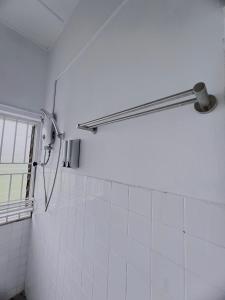 a shower in a bathroom with white tiles at The Cozy Place by Nestcove in Melaka