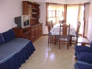 sala de estar con mesa de comedor y TV en El Ebro en Villa Gesell