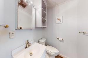 a white bathroom with a toilet and a sink at Evergreen in Moneta