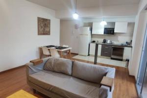 sala de estar con sofá y cocina en Lujoso departamento con Pileta en Villa Crespo- Camargo en Buenos Aires