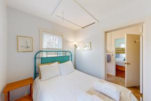 een witte slaapkamer met een bed en een raam bij Evergreen in Moneta