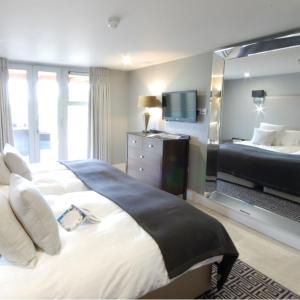 ein Hotelzimmer mit einem großen Bett und einem TV in der Unterkunft Apple Tree Lodges in Colchester