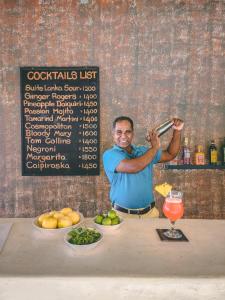 a man holding a wine glass in front of a table at Suite Lanka in Hikkaduwa