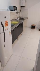 een keuken met een witte vloer en een koelkast bij Casa con pileta mirador de cabildo in La Punta