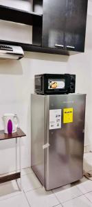 a microwave on top of a refrigerator in a kitchen at 2 BR staycation beside Enchanted Kingdom in Santa Rosa