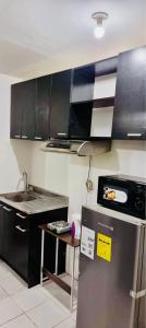 a kitchen with a refrigerator and a sink in it at 2 BR staycation beside Enchanted Kingdom in Santa Rosa