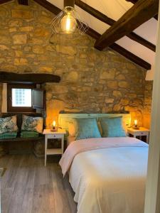 1 dormitorio con cama y pared de piedra en Casa Rural Vivienda Vacacional L´Curuxa Complejo CaleaCabo, en Biescas
