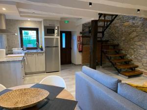 cocina y sala de estar con sofá azul en Casa Rural Vivienda Vacacional L´Curuxa Complejo CaleaCabo, en Biescas