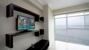 sala de estar con TV de pantalla plana en la pared en Riverfront I 1, piso 4, suite vista al rio, Puerto Santa Ana, Guayaquil, en Guayaquil