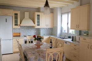 una cocina con una mesa con un jarrón de flores. en Summit Guest House, en Kalavrita