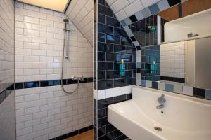 a bathroom with a sink and a shower at Bed & Bos de 14 Sterren in Den Burg +57 photos