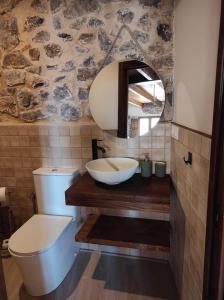 a bathroom with a sink and a toilet and a mirror at Casa el Recreo in Jérica