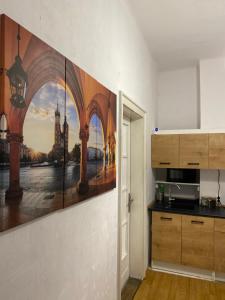 una cucina con un dipinto sul muro di Best View Old Town Rooms a Cracovia