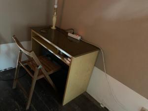 einen Schreibtisch mit einer Lampe und einem Stuhl in einem Zimmer in der Unterkunft BnB Convalis in Palermo