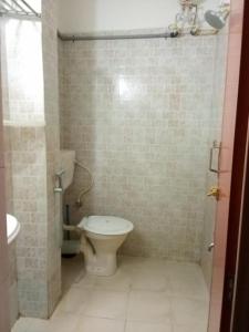 a bathroom with a toilet and a sink at KRK ROOMS Kottarakara in Kottārakara