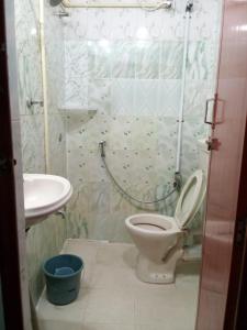 a bathroom with a toilet and a sink at KRK ROOMS Kottarakara in Kottārakara