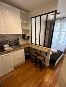 une petite cuisine avec un bureau et un lit dans une chambre dans l'établissement Beatrice et Emmanuel Meublé Eiffel, à Paris