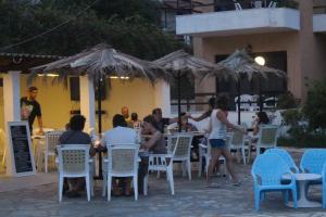 a group of people sitting at an outdoor restaurant at Le Mirage Hotel in Benitses +31 photos