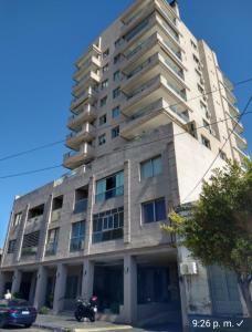 un edificio alto con una motocicleta estacionada frente a él en Torre Murano I en Corrientes