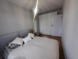 a bedroom with a large white bed with pillows at Apartament centrum in Ciechocinek