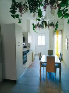 een keuken met een tafel en stoelen en een keuken met witte apparatuur bij Appartamento in centro Cuneo. in Cuneo