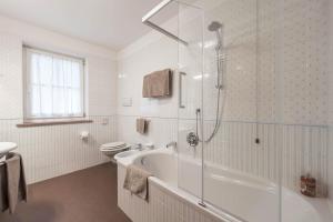 a bathroom with a tub and a toilet and a shower at Albergo Conturina in Canazei