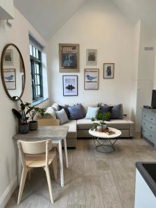 ein Wohnzimmer mit einem Sofa und einem Tisch in der Unterkunft Forge Cottage - Pretty 1 Bedroom Cottage with Free Off Street Parking in London