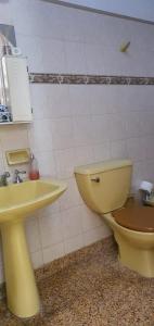 a bathroom with a yellow toilet and a sink at Casa Grande Salta pleno centro de la ciudad in Salta