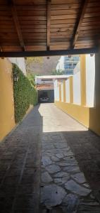 an empty walkway with a building and a wooden ceiling at Casa Grande Salta pleno centro de la ciudad in Salta