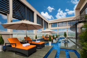 un patio al aire libre con sillas y sombrillas en un edificio en Luxury Beach Condo 5-star, Rooftop pool, en Da Nang