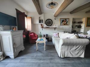 salon z białą kanapą i kominkiem w obiekcie Maison ancienne romantique avec terrasse panoramique w mieście Vaison-la-Romaine