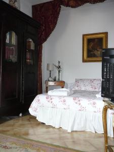 1 dormitorio con 1 cama y TV. en La Terrazza dei Pelargoni B&B en Ventimiglia