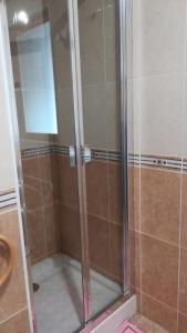 La salle de bains est pourvue d'une douche avec une porte en verre. dans l'établissement Gîte du Pressoir, à Cerdon