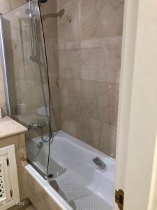 bagno con doccia e vasca bianca di Roda Golf Resort ;Casa Sylva a San Javier
