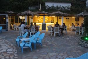 a group of people sitting at tables in a restaurant at Le Mirage Hotel in Benitses